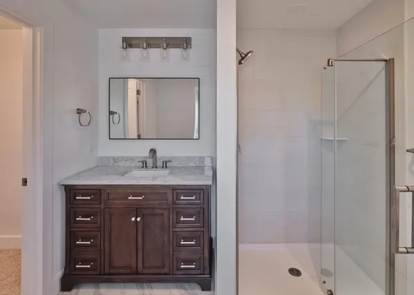 a bathroom with a granite countertop sink a toilet and shower