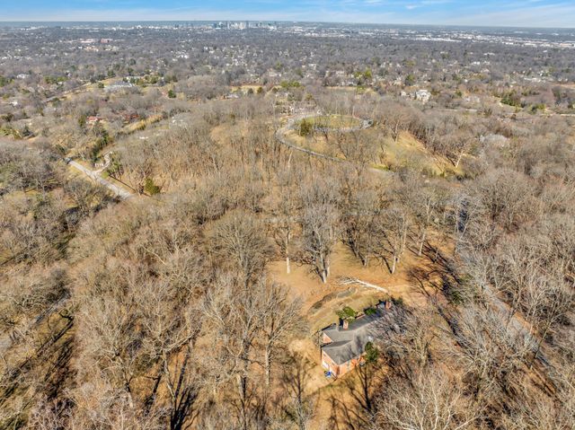 an aerial view of residential houses with outdoor space and trees