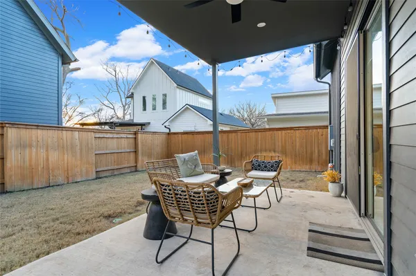 a view of a patio with table and chairs with wooden fence