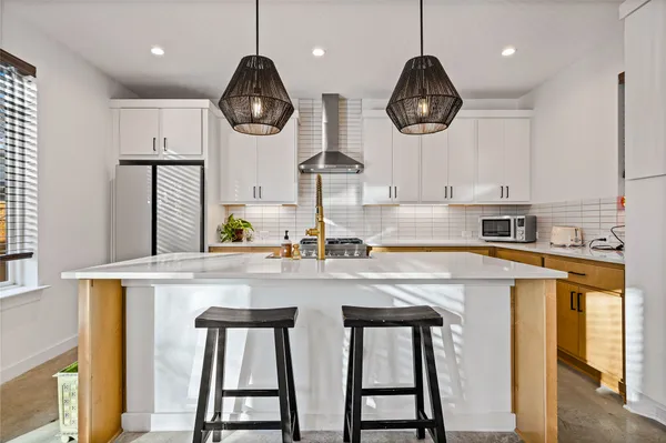 a kitchen with stainless steel appliances kitchen island granite countertop a stove a sink and a refrigerator