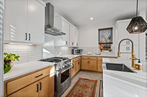 a kitchen with stainless steel appliances granite countertop a sink a microwave a stove and a cabinets