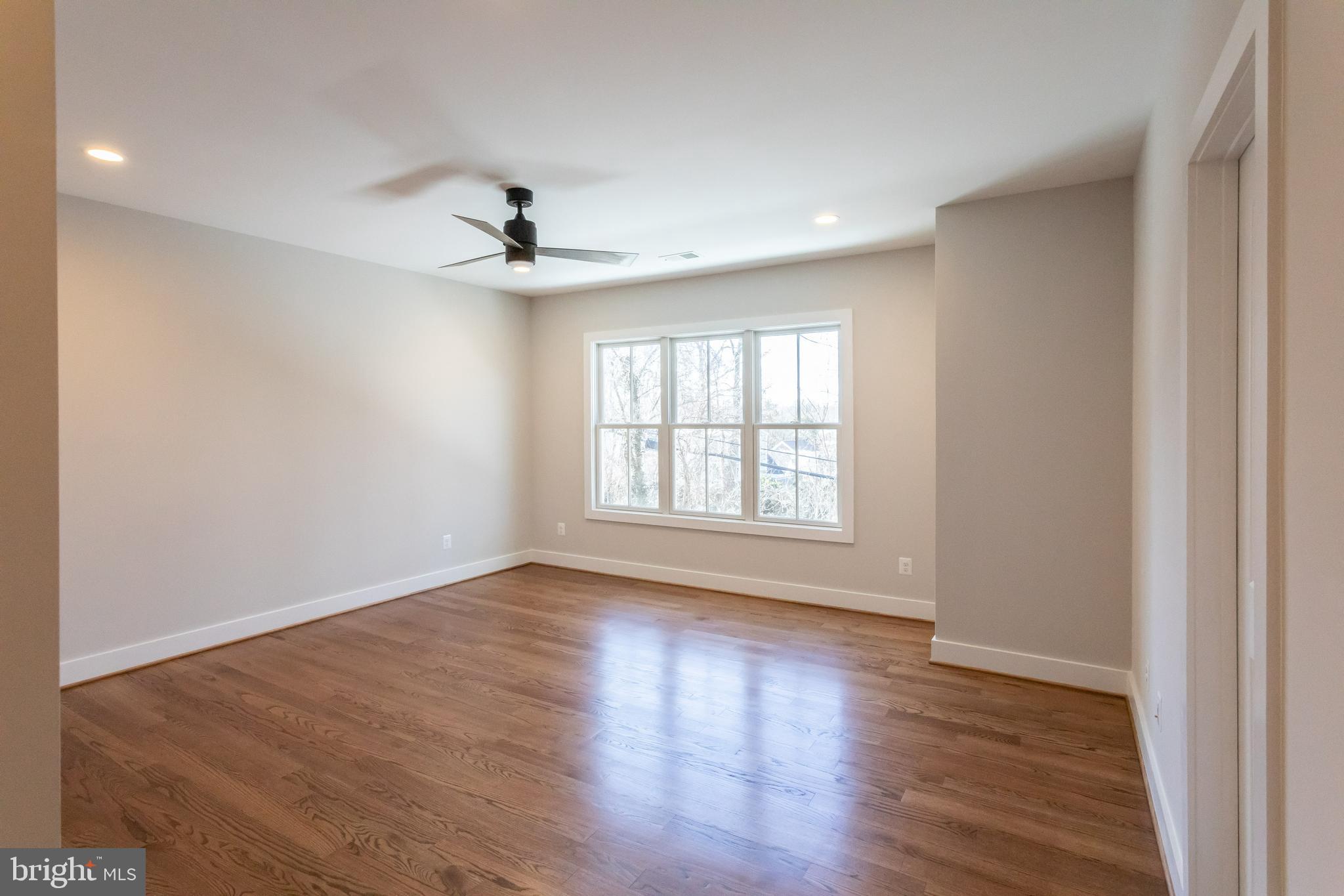 734 North Wakefield Street Arlington, VA 22203 - Photo 18 of 26 an empty room with wooden floor ceiling fan and windows