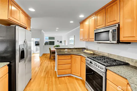 a kitchen with stainless steel appliances granite countertop a stove a sink and a microwave
