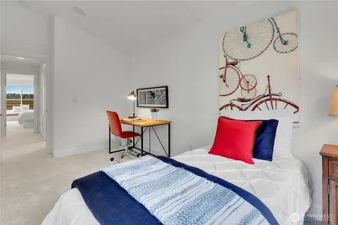 a bedroom with a bed and table chair