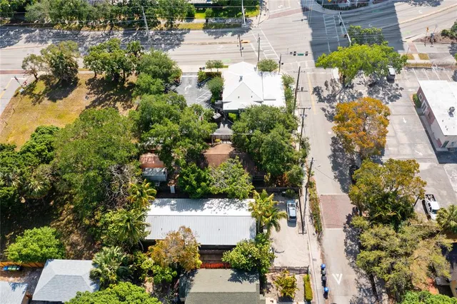 an aerial view of residential house with outdoor space and trees all around