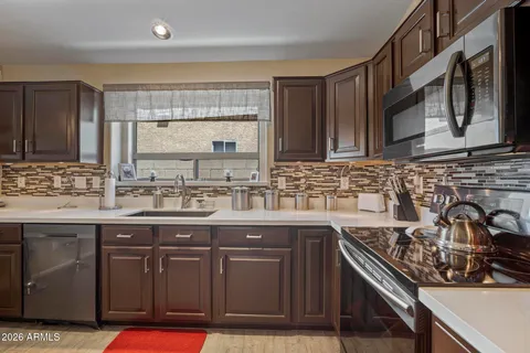 a kitchen with stainless steel appliances granite countertop a sink stove and cabinets