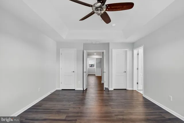 a view of a big room with wooden floor and windows