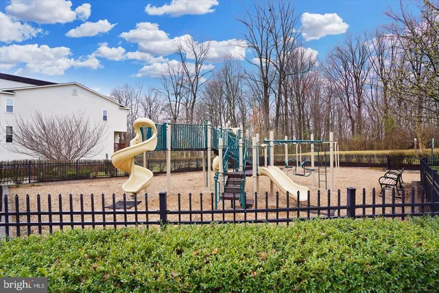 a front view of a house with garden and trees