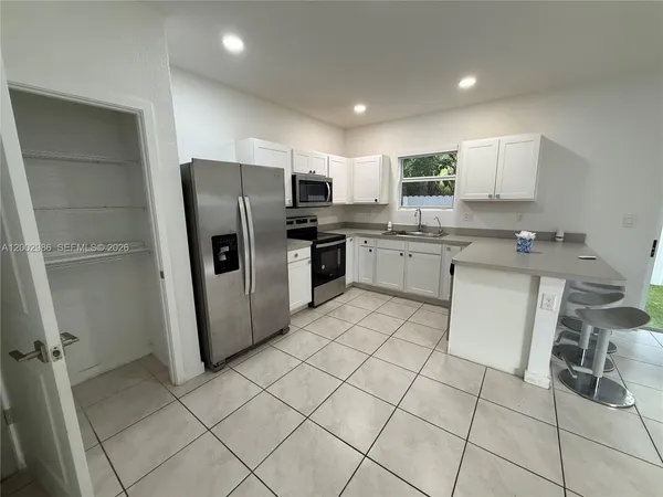 a kitchen with a sink a refrigerator and cabinets