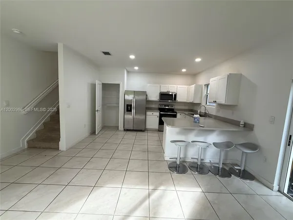 a kitchen with stainless steel appliances a refrigerator sink and cabinets