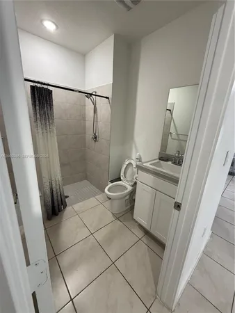 a bathroom with a granite countertop shower and a toilet