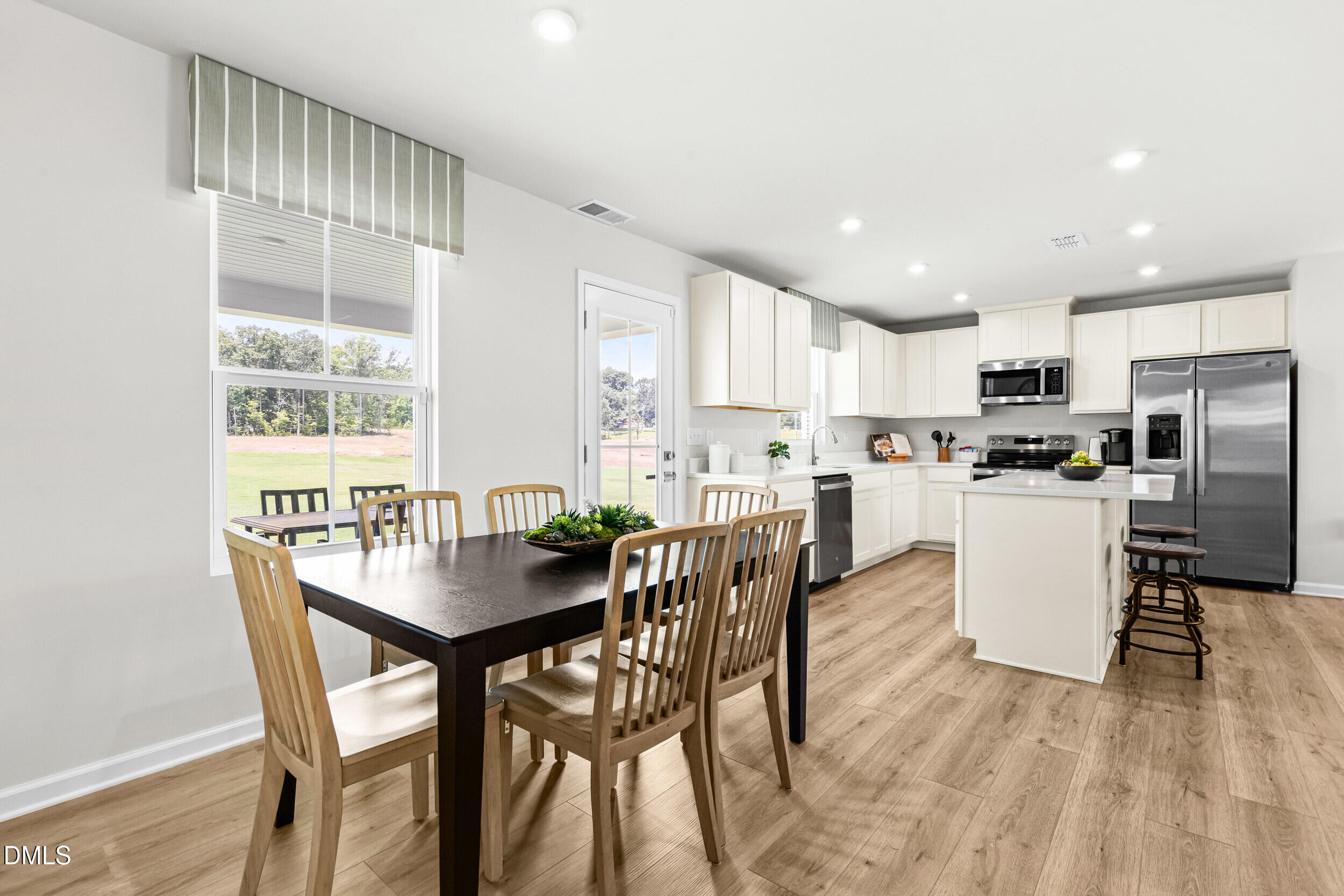 197 Brook Bawn Road Wendell, NC 27591 - Photo 6 of 33 a kitchen with a dining table chairs and refrigerator
