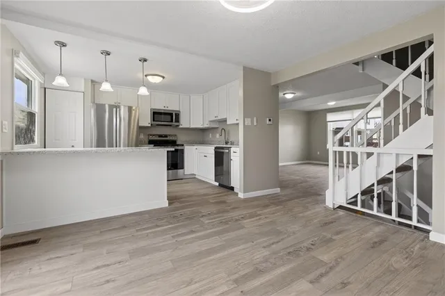 a view of kitchen with wooden floor and electronic appliances