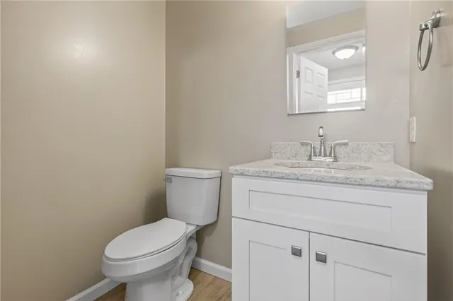 a bathroom with a granite countertop toilet sink and mirror