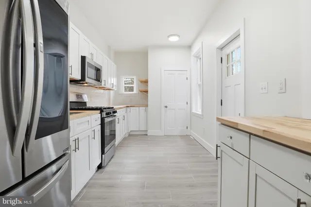 a kitchen with white cabinets and stainless steel appliances