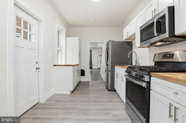 a kitchen with stainless steel appliances a refrigerator stove and microwave