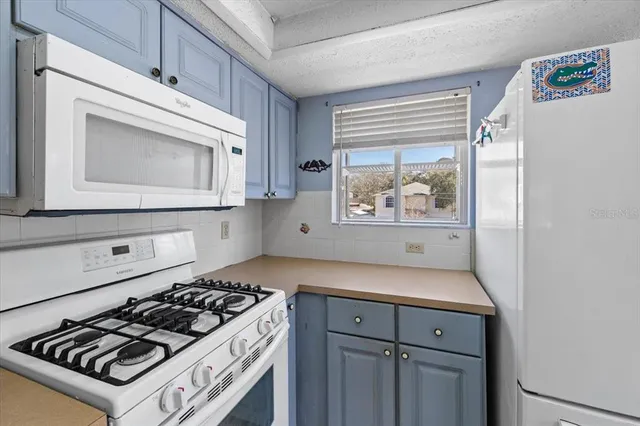 a white stove top oven sitting inside of a kitchen