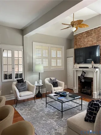 a living room with furniture a flat screen tv and a fireplace
