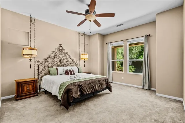 a bedroom with a bed a chandelier and large window