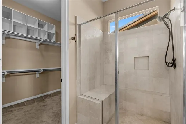 a bathroom with a shower and a glass door
