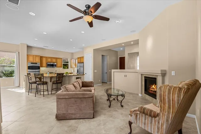 a living room with furniture a fireplace and a dining table with wooden floor