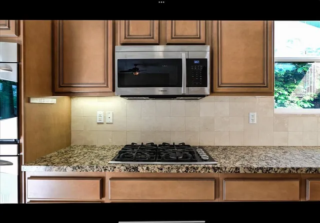 a kitchen with stove top oven and cabinets