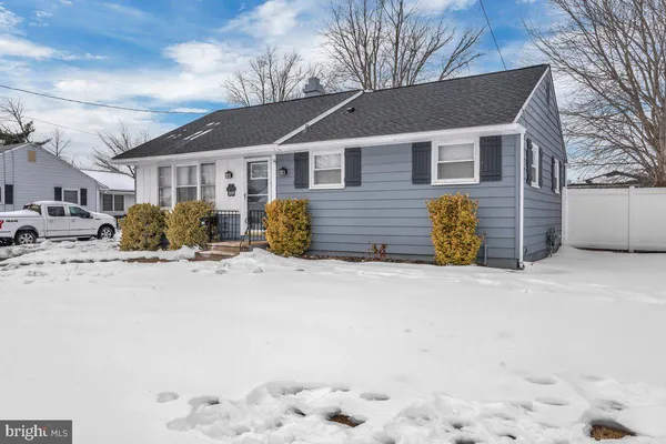 a front view of a house with a yard covered in snow