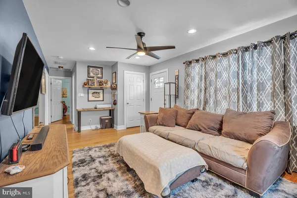 a living room with furniture ceiling fan and a rug