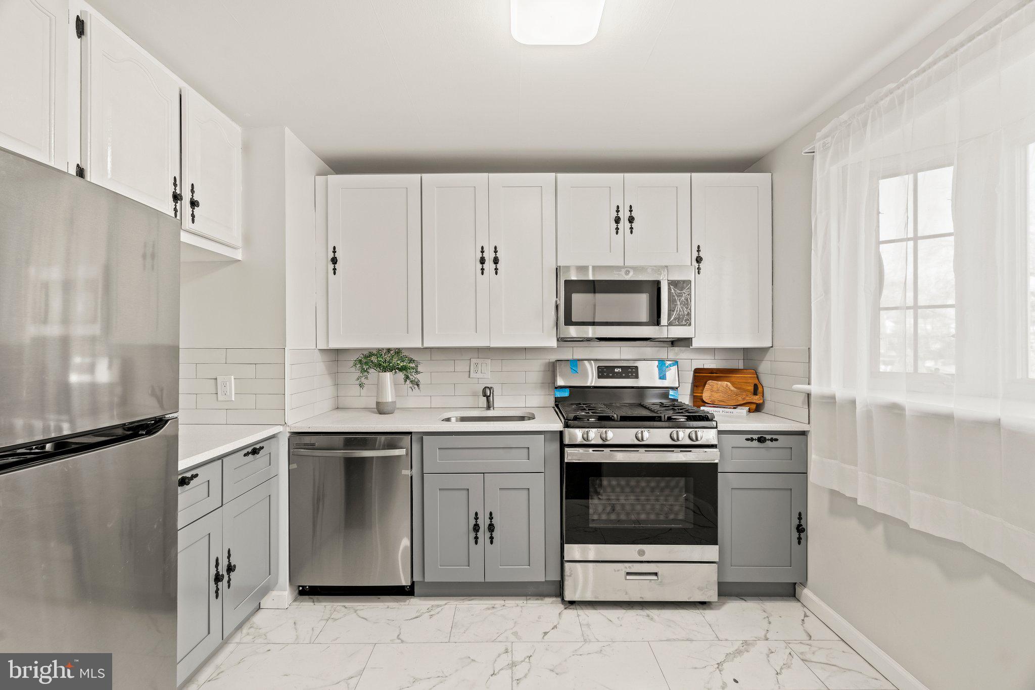 3129 Fairdale Road Philadelphia, PA 19154 - Photo 12 of 17 a kitchen with stainless steel appliances a stove sink and cabinets