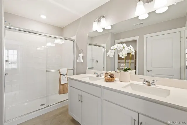 a bathroom with a double vanity sink mirror and shower
