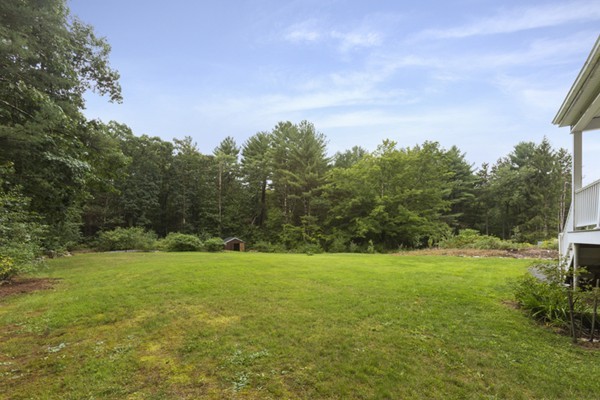 152 Littlefield Road Boxborough, MA 01719 - Photo 10 of 10 a view of a grassy field with trees in the background