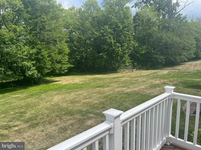 a view of a green field with wooden fence