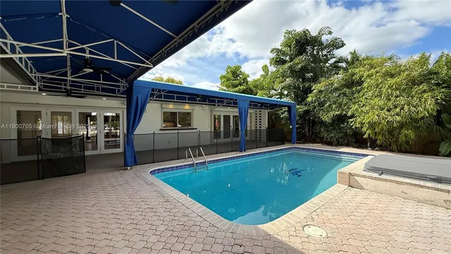 a view of a house with pool fire pit couches with wooden floor
