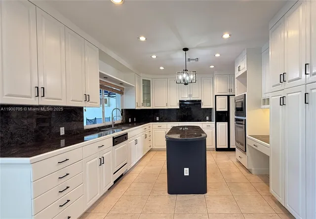 a large kitchen with kitchen island granite countertop a refrigerator and a stove top oven