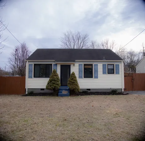 a view of house with backyard and trees in the background