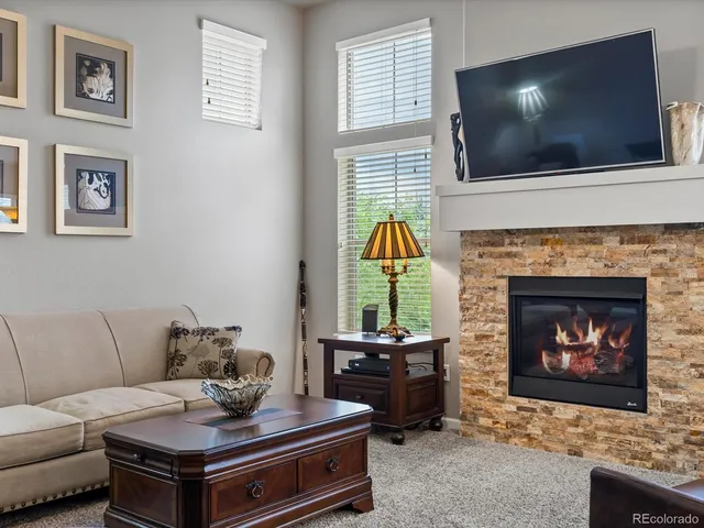 a living room with furniture a flat screen tv and a fireplace