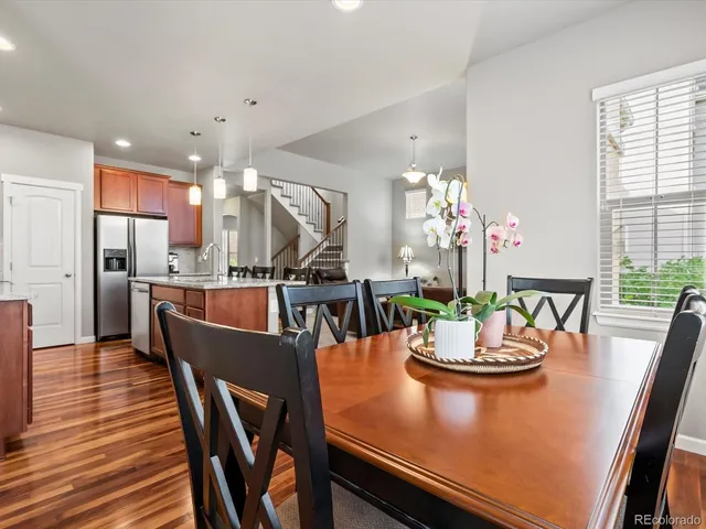 a view of a dining room with furniture a chandelier and wooden floor