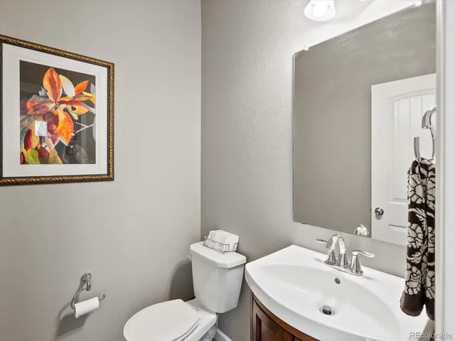 a bathroom with a toilet a sink and mirror
