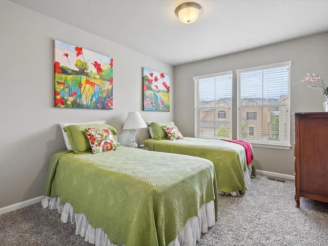 a bedroom with two beds and painting on the wall