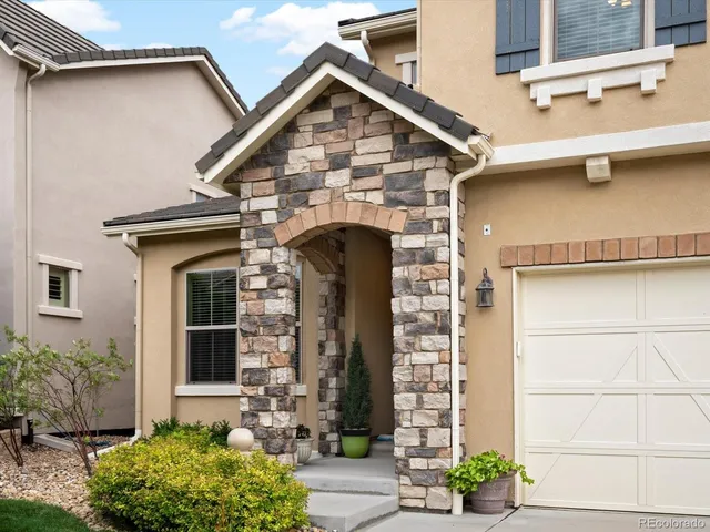 a front view of a house with plants
