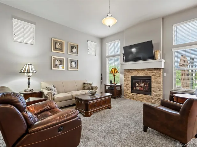 a living room with couches a fireplace and a flat screen tv