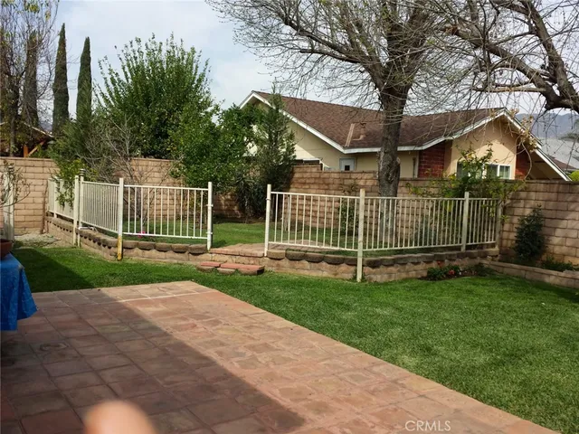 a view of a white house with a big yard and large trees