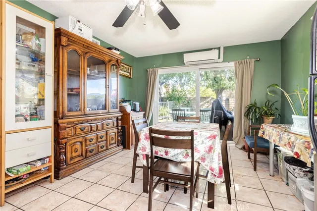 a dining room with furniture a flat screen tv and a floor to ceiling window
