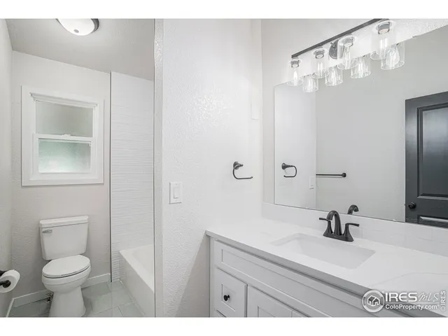 a backyard of a house with large trees and outdoor seating