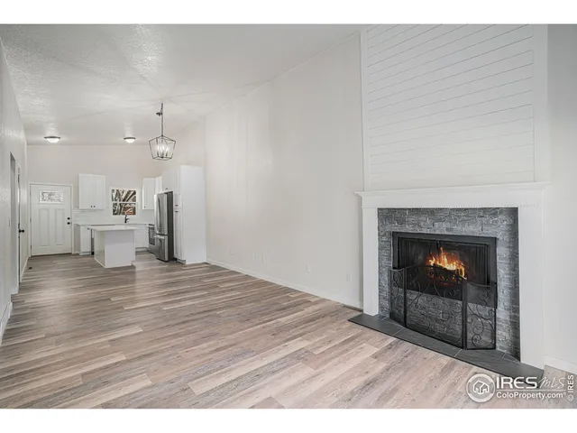 a view of a livingroom with wooden floor and a fireplace