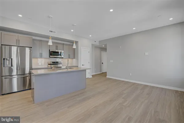 a large kitchen with a refrigerator and a sink