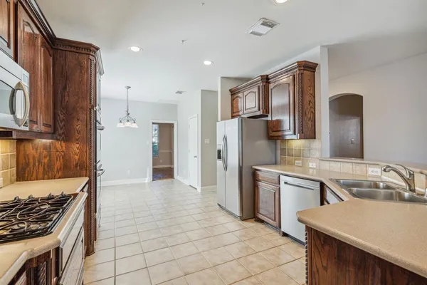 a kitchen with stainless steel appliances granite countertop a sink stove and refrigerator