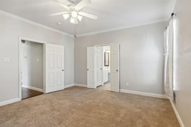 a view of an empty room and chandelier fan