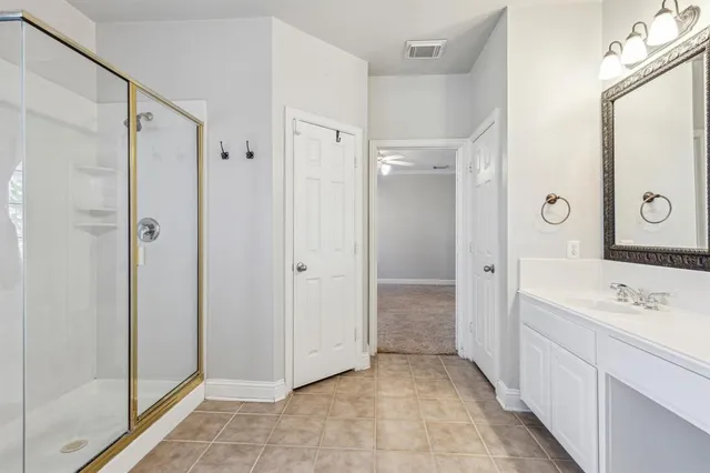 a spacious bathroom with a shower sink and mirror