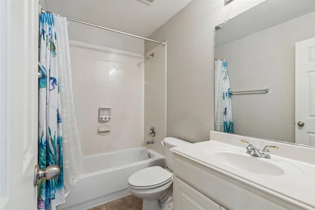 a bathroom with a sink a toilet a mirror a bathtub and shower
